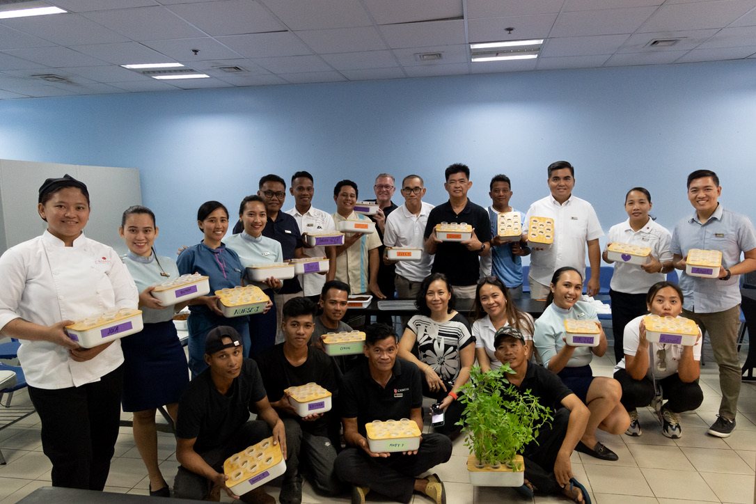 Around twenty Crimson staff from kitchen, housekeeping, engineering and grounds holding their planted trays after training